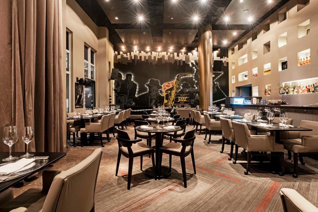 Restaurante do FULL JAZZ. Várias mesas com taças em cima, e poltronas. 