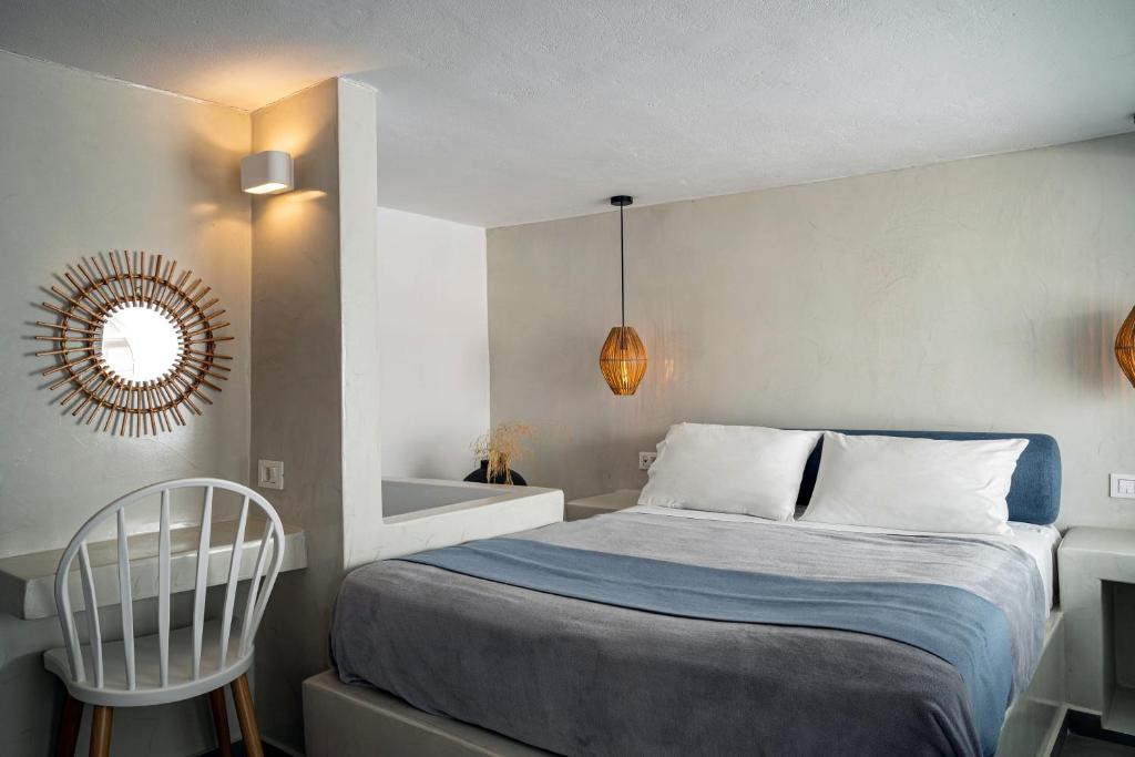 Quarto moderno com uma cama bem arrumada, uma escrivaninha e cadeira, espelho decorativo e duas luminárias penduradas em cada lado da cama.