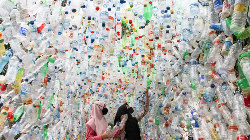 Young Indonesian environmental activists decorate a room with plastic bottle waste collected from a river.