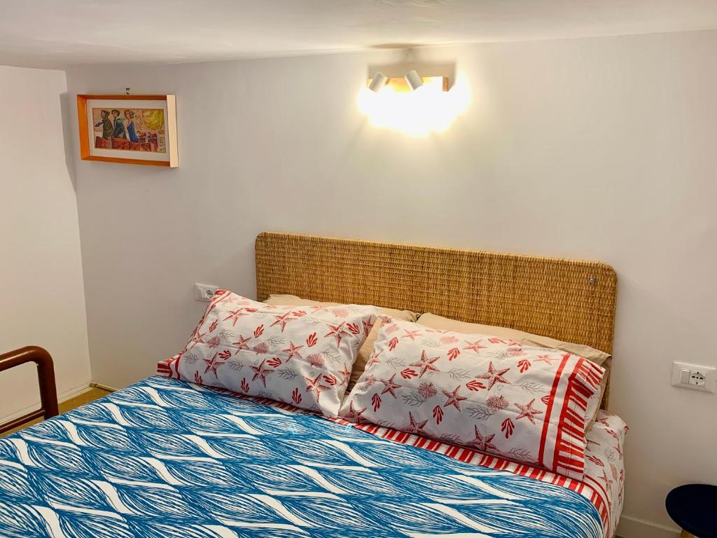 quarto do Maelle Trastevere, um airbnb em Roma, mostrando a cama no segundo andar que se sobe de escada, há travesseiros e luz acima