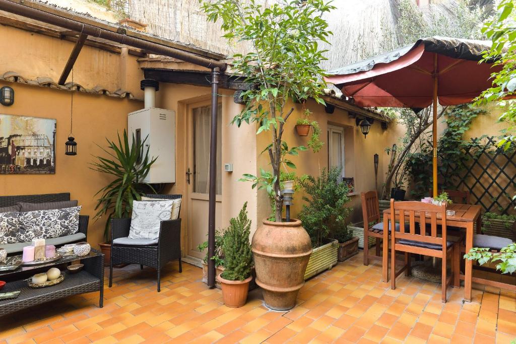 terraço na área externa do Malva, com banco e mesa de madeira, sofás e muitas plantinhas 
