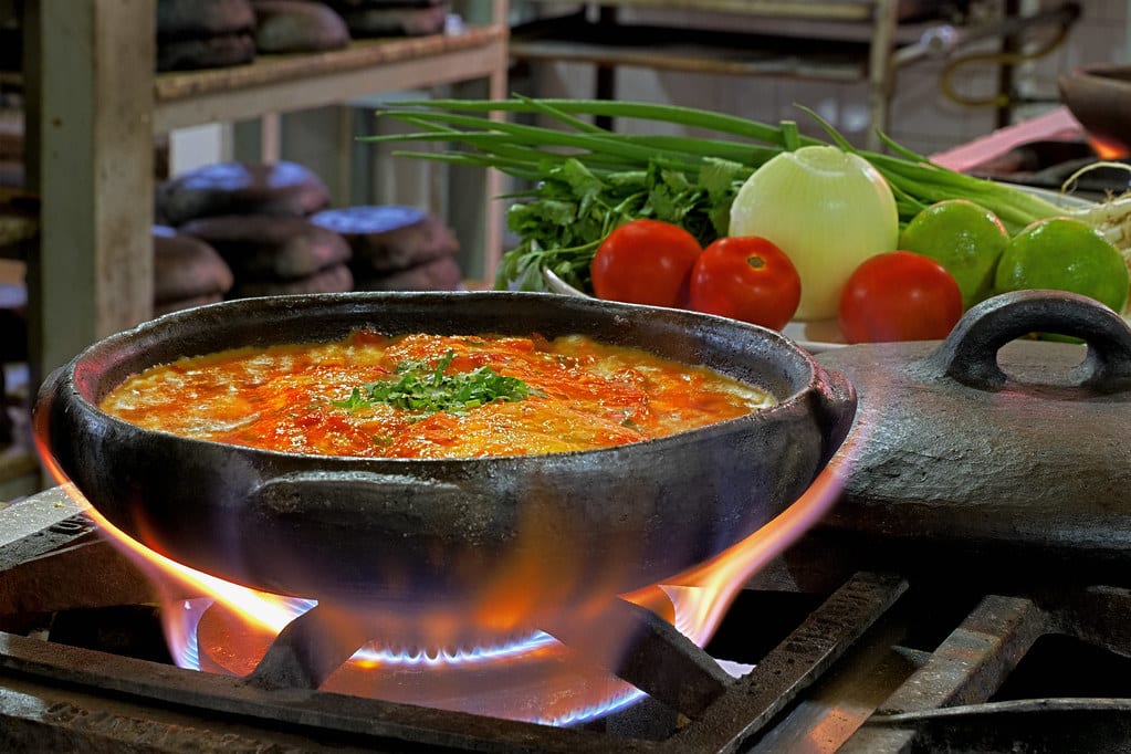 Moqueca capixaba sendo preparada em panela de barro.