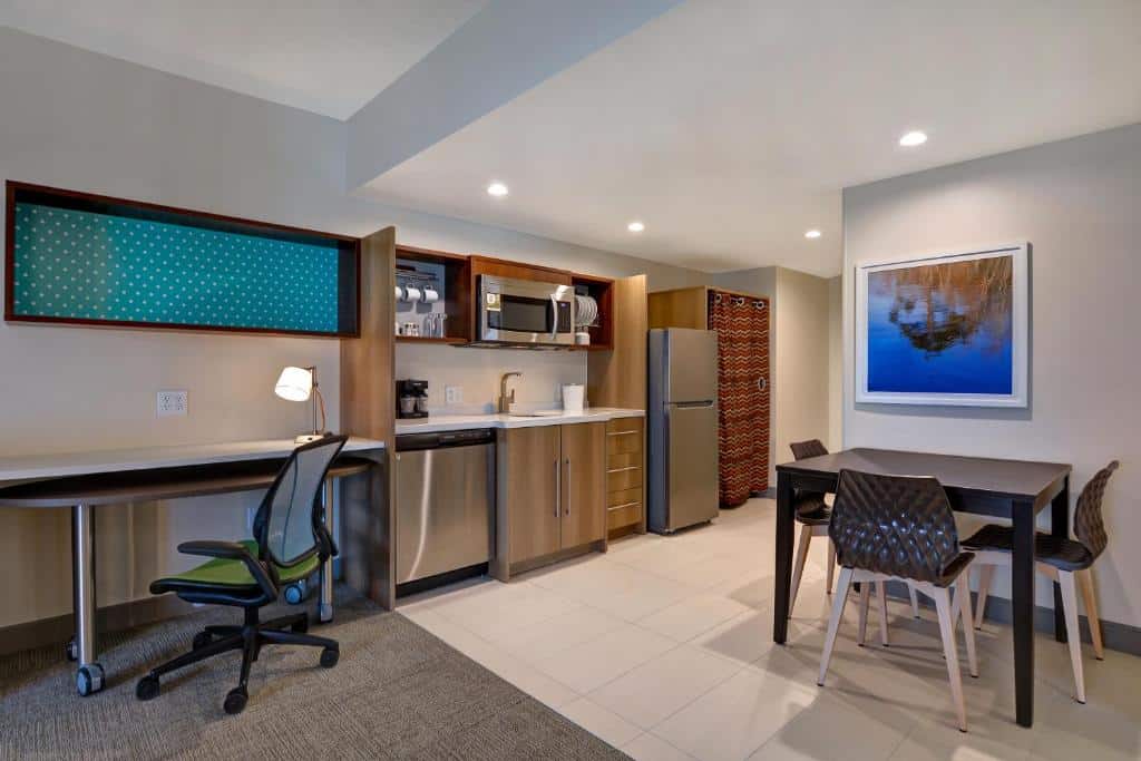 quarto com cozinha contando com mesa e cadeiras, geladeira, micro-ondas, forno, armários e louça no Home2 Suites By Hilton Orlando Flamingo Crossings, FL, um dos hotéis com cozinha em Orlando