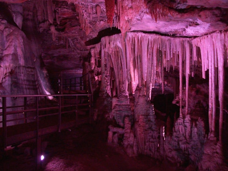 A Gruta Rei do Mato, a 62 quilômetros de Belo Horizonte, na cidade de Sete Lagoas. Na imagem podemos ver o interior da caverna, com pontes e luzes artificiais para os turistas poderem se locomover lá dentro. Há várias estalagmites suspensas no teto da caverna e diversas formações rochosas.