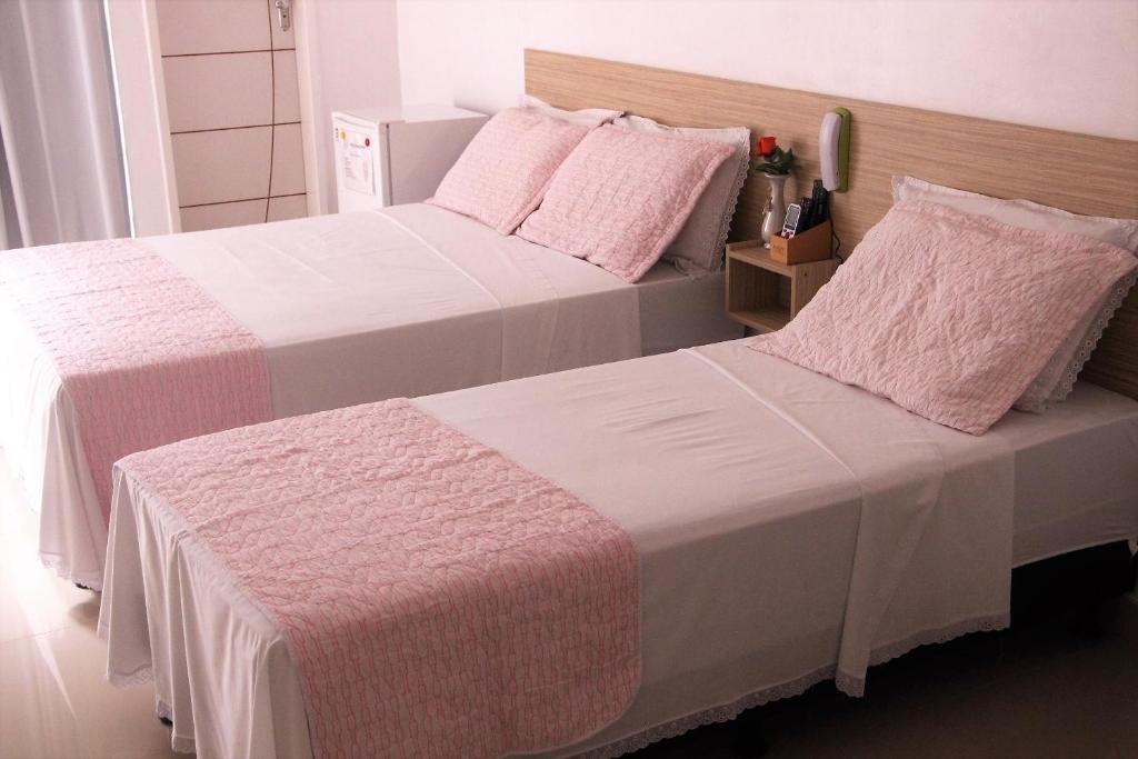Quarto no Hotel Marajoara com duas camas, uma de casal e outra de solteiro. É possível ver um telefone entre elas e um frigobar ao lado da porta, para representar hotéis em Belém do Pará.