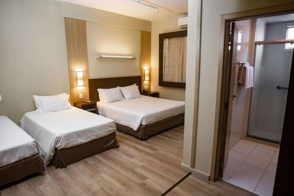 Quarto com cama de casal e duas de solteiro no Master Cosmopolitan Moinhos de Vento, um dos hotéis em Porto Alegre indicados