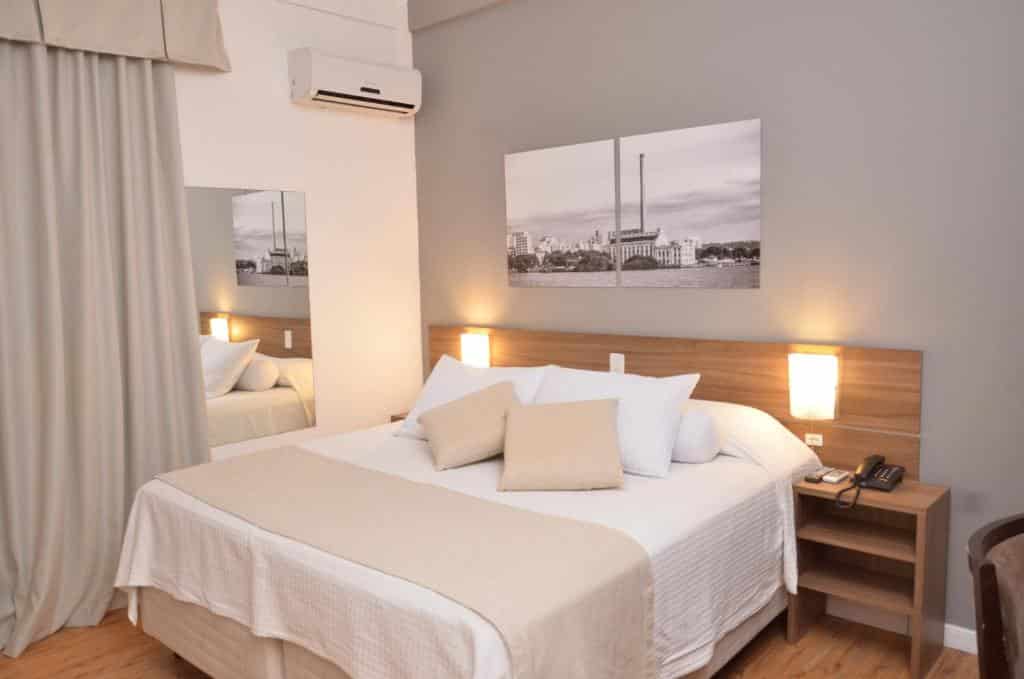 suíte do Açores Premium, um dos hoteis em porto alegre, com ar-condicionado, espelho de corpo inteiro e cortina blackout