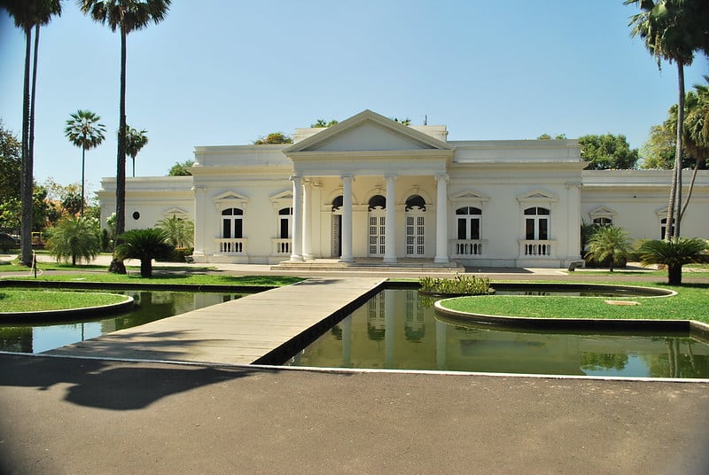 Ponto turístico em Teresina chamado Palácio de Karnak. Grande construção branca com gramado a frente e ponte acima de um pequeno lago.