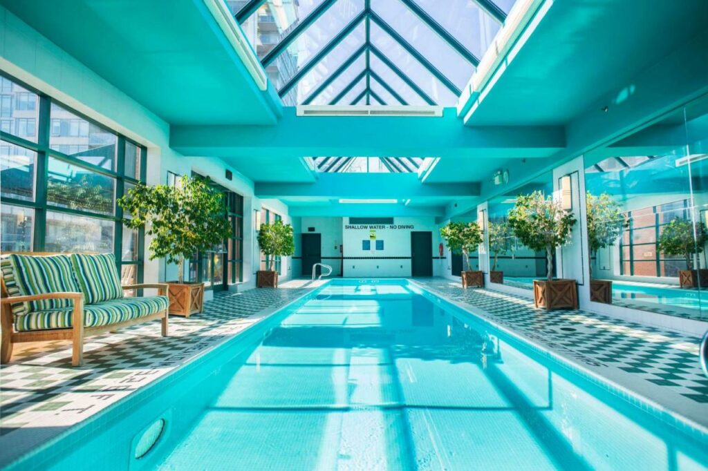 Piscina coberta no The Yorkville Royal Sonesta Hotel Toronto com um deck em tons de azul e com alguns vasos de plantas