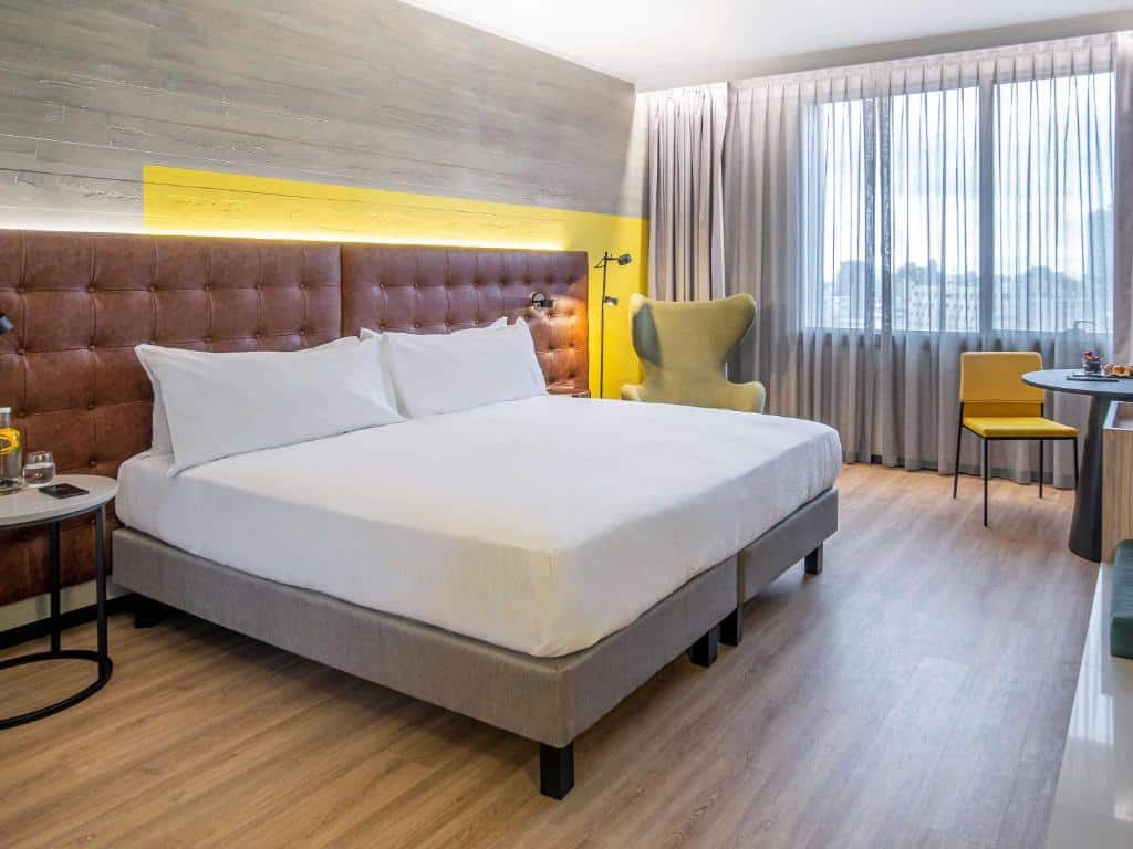 Quarto do Pullman Santiago El Bosque com cama de casal do lado esquerdo, uma poltrona do lado esquerdo.
