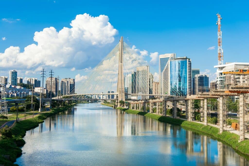 Ponte estaiada que atravessa o rio com várias construções em volta e prédios altos durante o dia, ilustrando post Hotéis Mercure em São Paulo.
