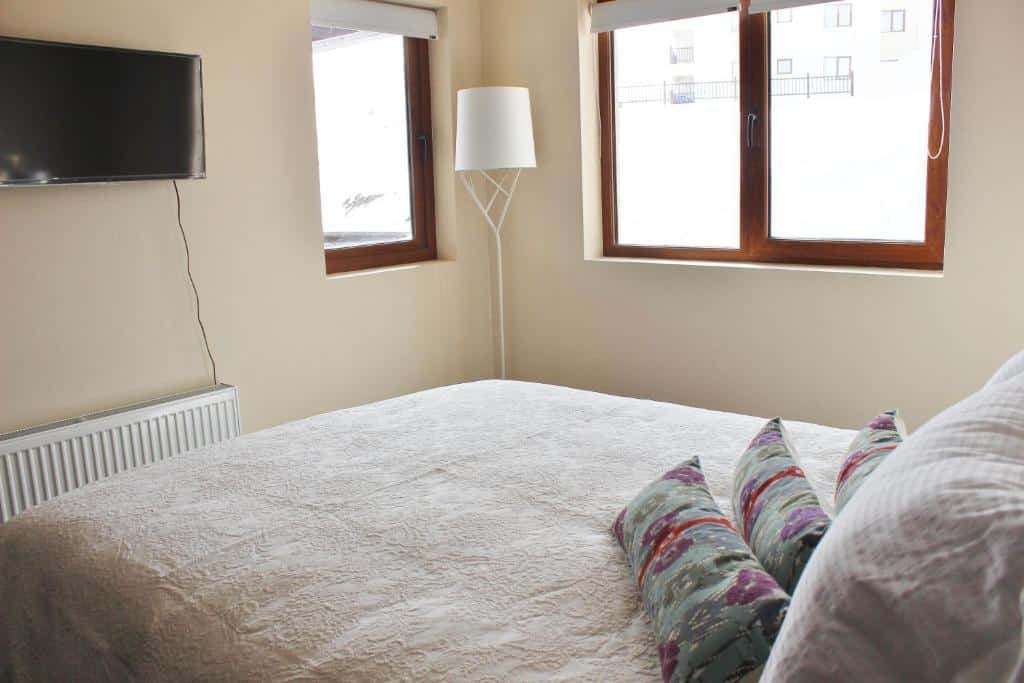 Quarto do Valle Nevado Vip Apartment Ski Out-In com cama de casal do lado direito e em frente a cama uma TV. 
