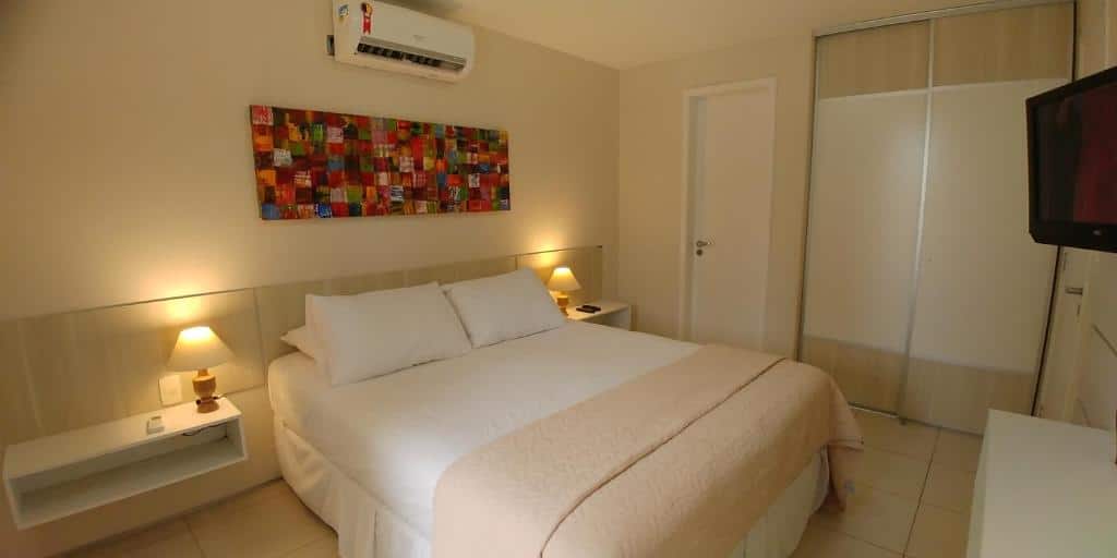 Quarto do Atlantic Palace Family inn com cama de casal, duas cômodas ao lado com luminárias e TV em frente da cama, para representar hotéis perto do Beach Park.
