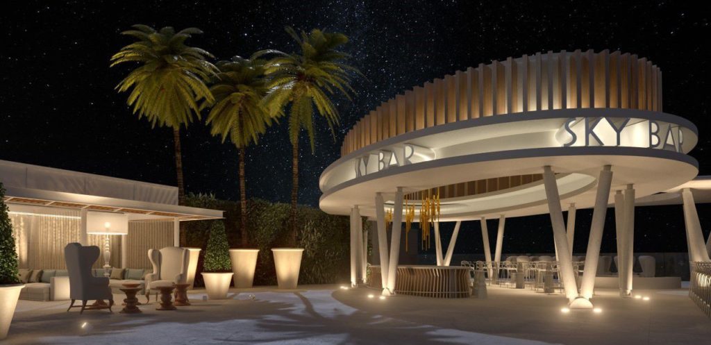 Bar ao ar livre no Grand Palladium Select Costa Mujeres à noite com assentos modernos, palmeiras e um céu estrelado ao fundo.