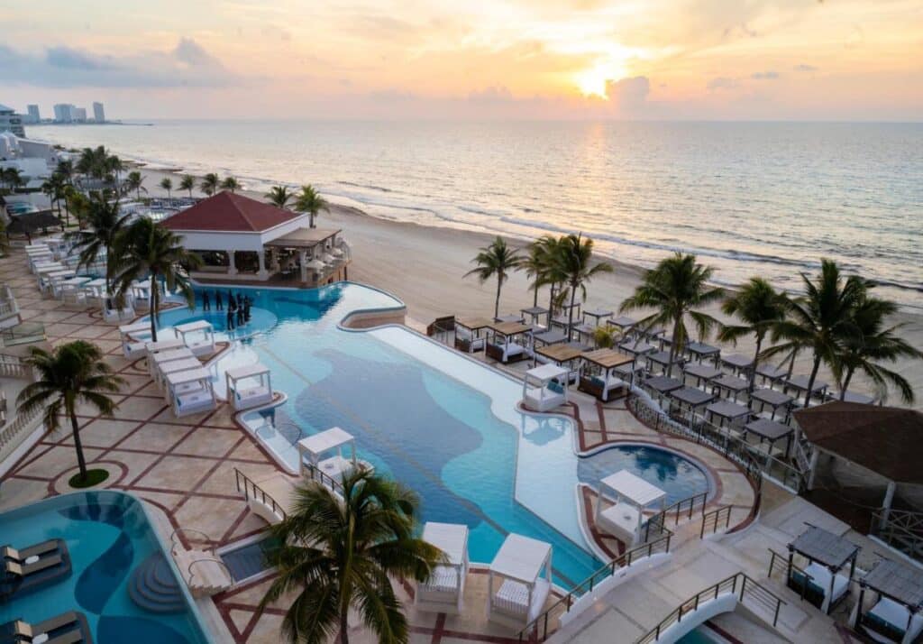 O Hyatt Zilara Cancun fica à beira-mar conta com diversas piscinas, cabanas e palmeiras com vista para o oceano ao pôr do sol. Esse é um dos melhores resorts all inclusive no Caribe.