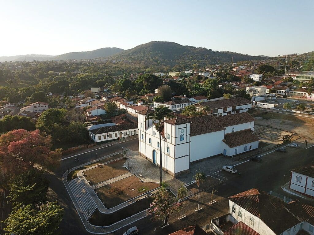 Vista geral de Pirenópolis e da Igreja Matriz de Nossa Senhora do Rosário. A igreja fica no meio da imagem, rodeada por casinhas e muita vegetação.