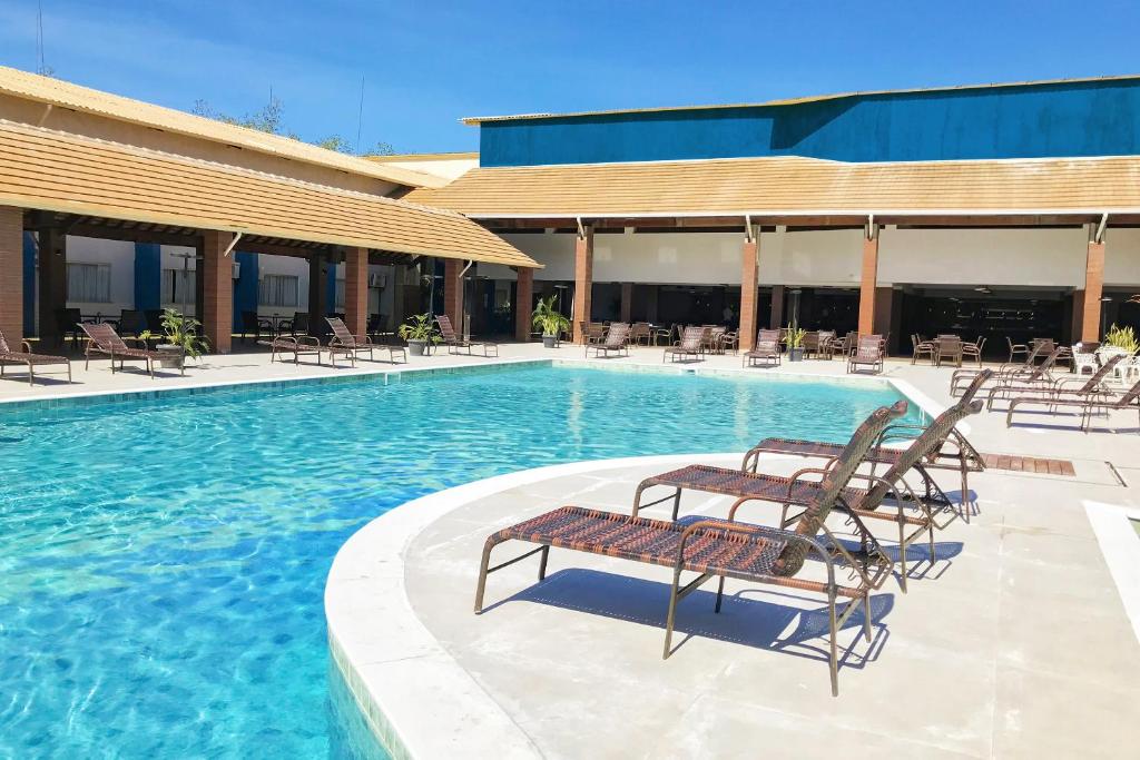 Piscina do Nauticomar Resort & Beach Club em Porto Seguro, um dos resorts em Porto Seguro, com espreguiçadeiras em volta