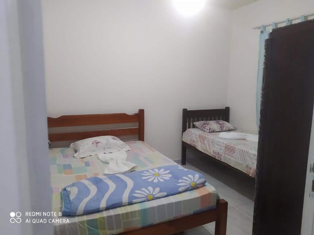 Quarto do airbnb Casa 3 quartos com Piscina. No lado direito da imagem há uma cama de solteiro e é possível ver uma pequena parte de um armário. Já no lado esquerdo há uma cama de casal. Imagem para ilustrar o post airbnb em Itatiaia.