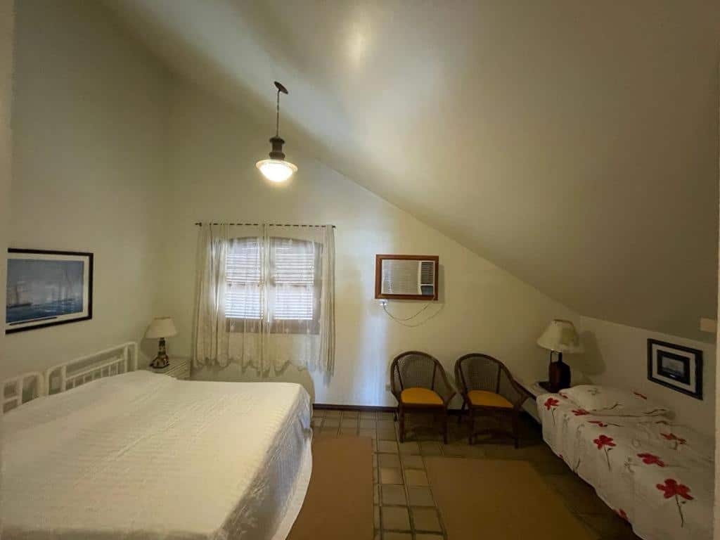 Quarto familiar da Guaeca Villa com cama de casal do lado esquerdo da imagem e do lado direito uma cama de solteiro. Representa airbnb em Toque-Toque Grande.