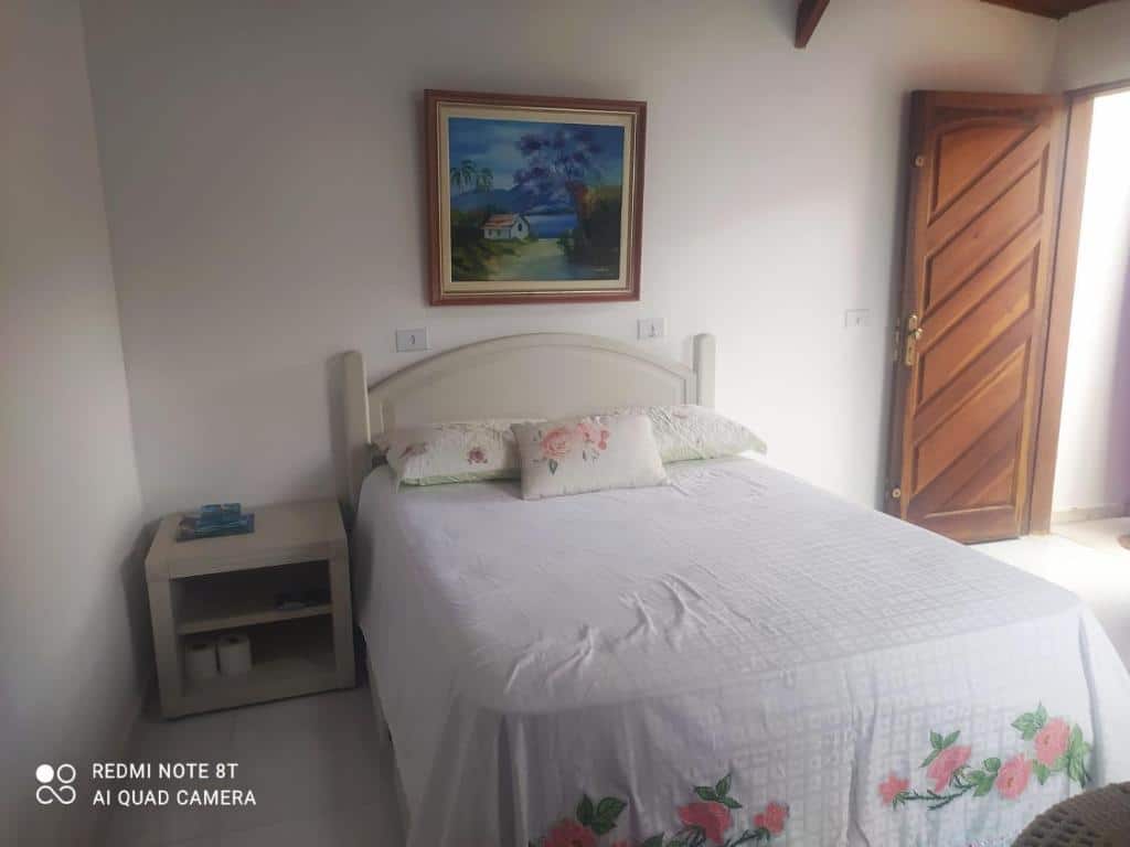 Quarto do Cantinho de Barê com uma cama do centro do ambiente com uma cômoda do lado direito da cama, para representar airbnb na praia do Guaecá.