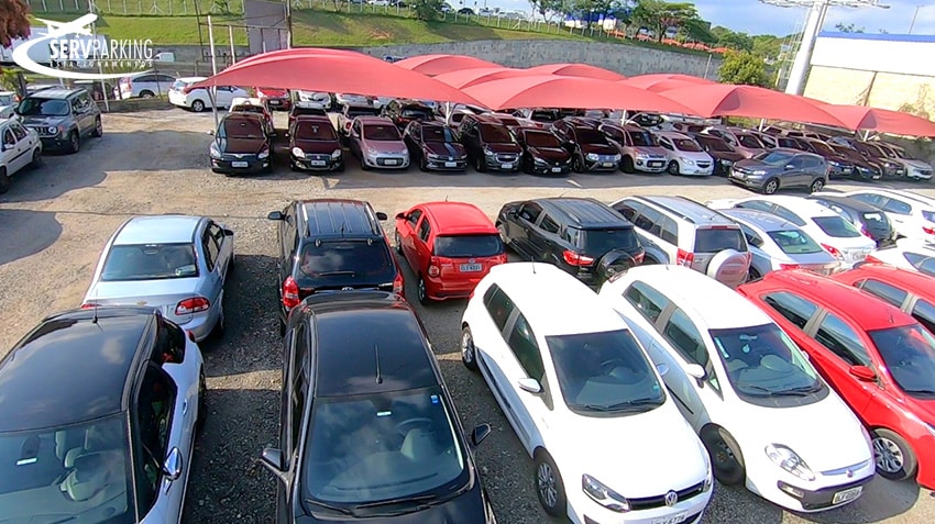 Estacionamento ServParking com fileiras de carros cobertas por toldos e outras ao ar livre