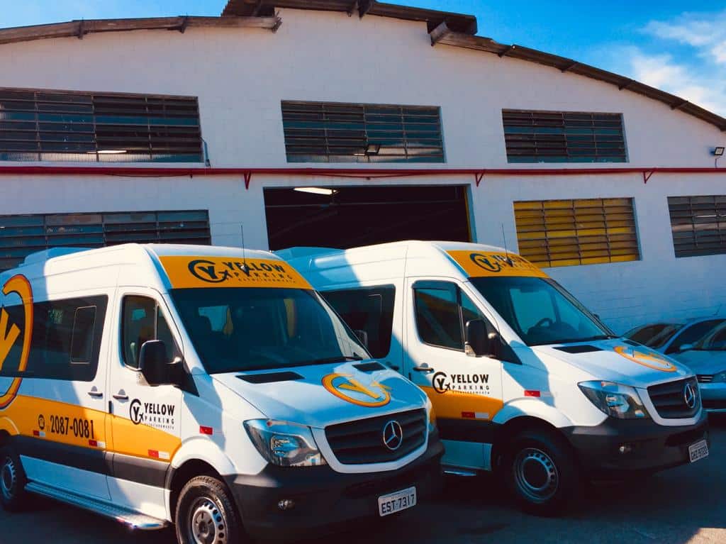 Vans do Yellow Parking estacionadas em frente um galpão