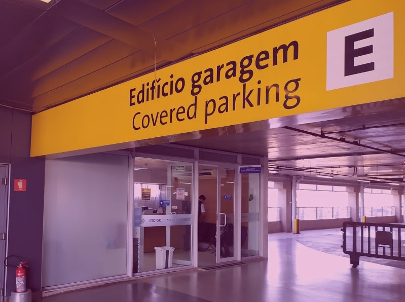 Parte interna do Aeroporto de Guarulhos com sinalização para o estacionamento da Indigo com uma pequena recepção