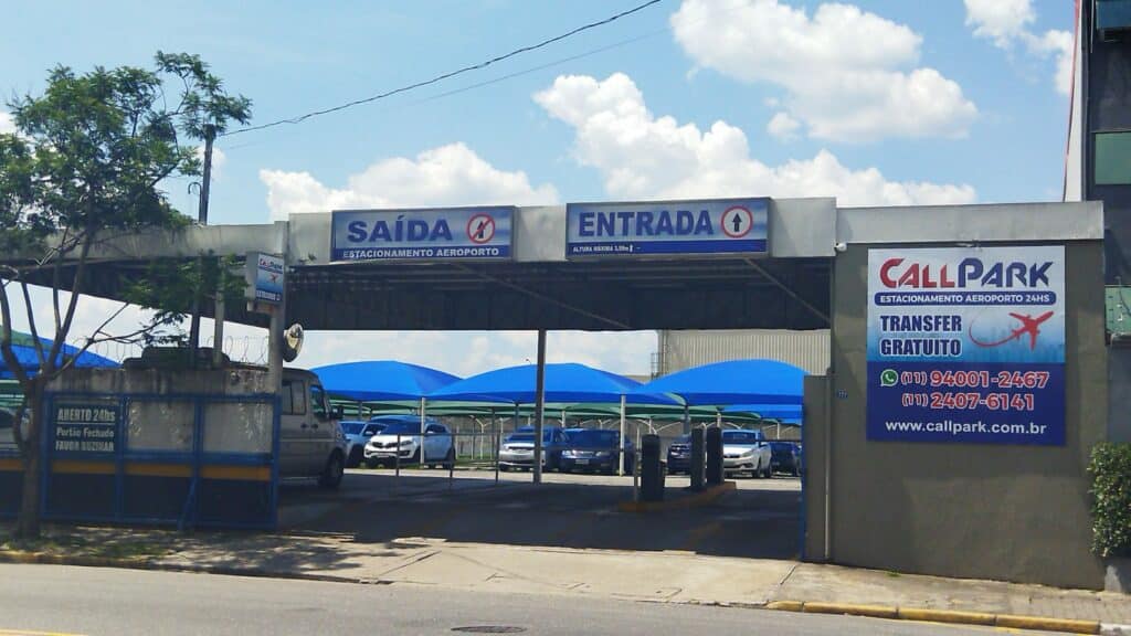 Entrada do Call Park com vagas cobertas por toldos azuis e algumas placas fazendo propagando do local no muro do lado de fora