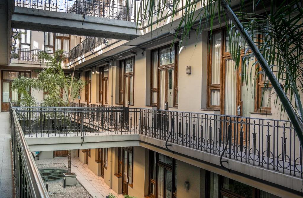 fachada interna vista do segundo andar do Up Tribeca, um dos hotéis 3 estrelas em Buenos Aires, com várias portas e tons de amarelo e marrom e plantinhas ao redor