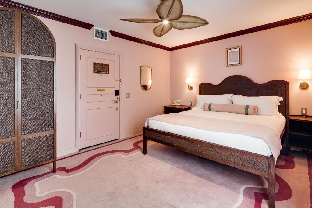 Imagem do quarto do Esme Miami Beach com cama de casal do lado direito da imagem no centro do quarto com uma cômoda em cada lado da cama, no teto no centro um ventilador. Representa hotéis boutique em Miami.