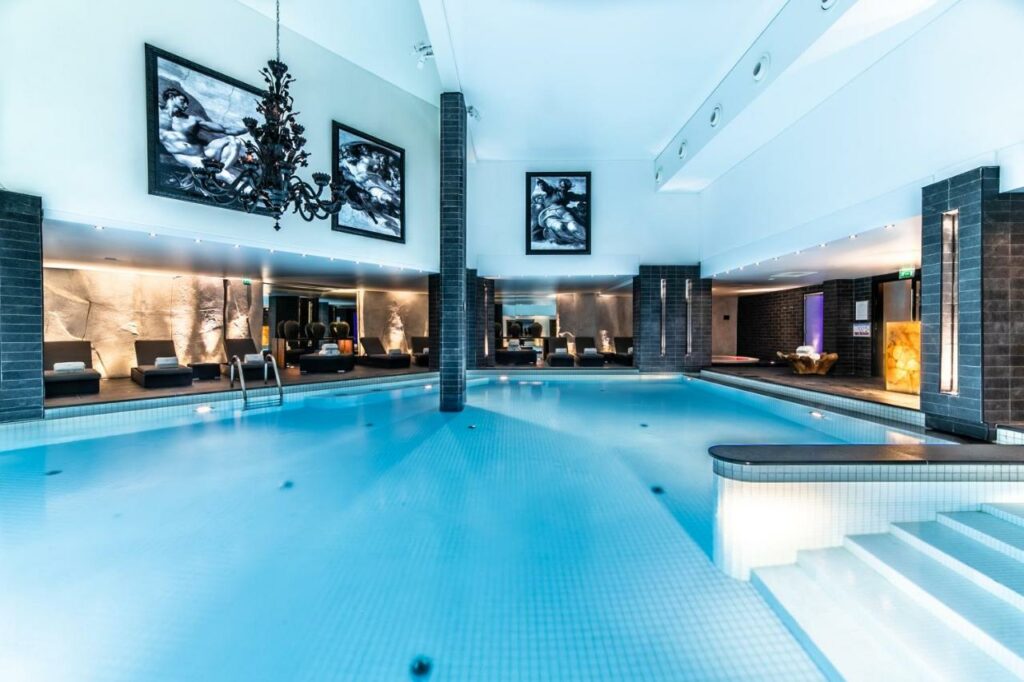 Piscina do hotel Le Strato. A área é toda coberta e há cadeiras de piscina em volta dela.