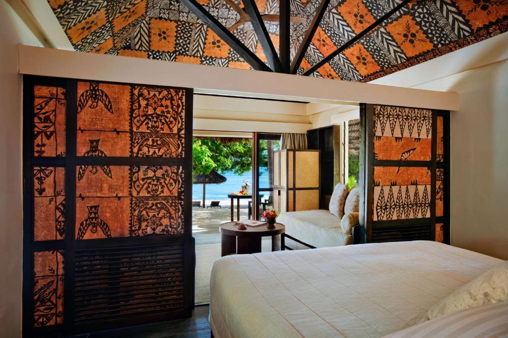 Quarto do Castaway Island com cama de casal, a frente uma pequena área de estar que dá acesso a varanda térrea próximo do mar.