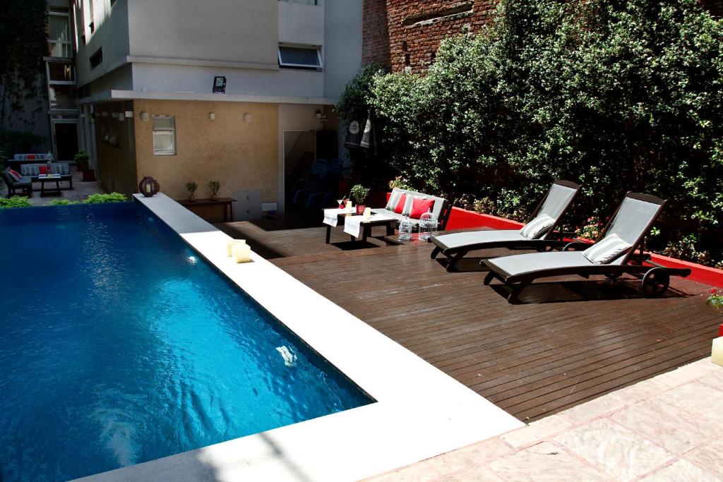Vista de uma piscina retangular no Ribera Sur Hotel, em San Telmo, Buenos Aires, com espreguiçadeiras e plantas ao redor.