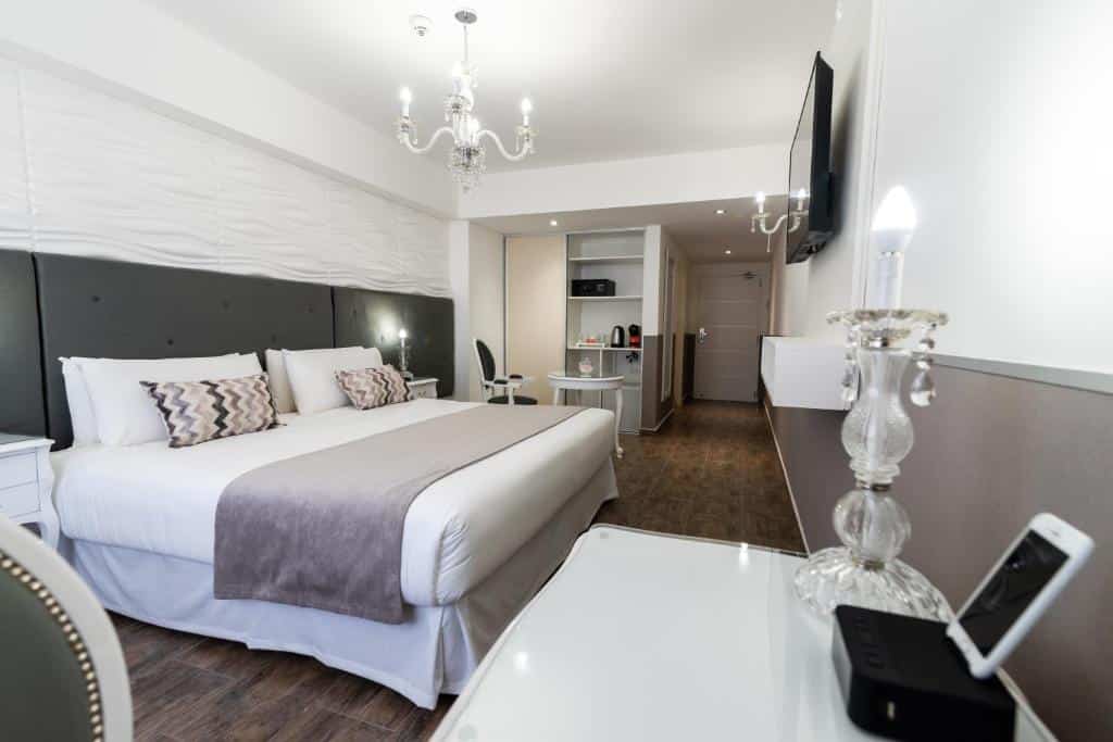 quarto amplo do Ker San Telmo Hotel com cama de casal, tv em frente e escrivaninha, do lado há uma mesa com cadeiras e estante com comodidades para fazer chá