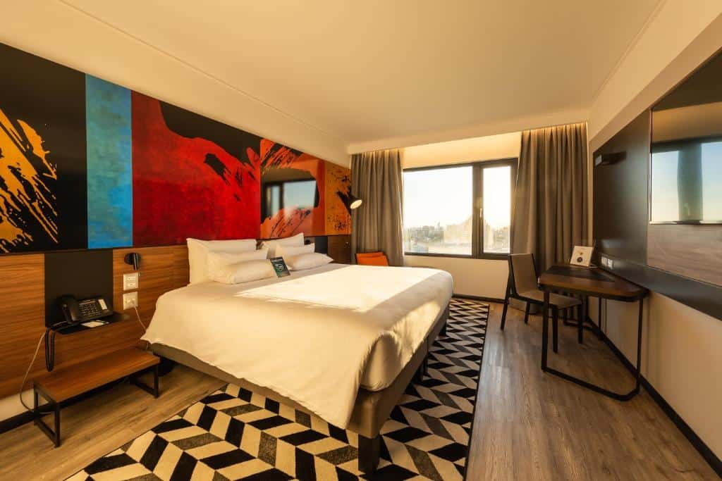 Quarto do Novotel Santiago Providencia com cama de casal do lado esquerdo em frente a cama TV e mesa de trabalho ao lado, para representar hotéis Mercure em Santiago.