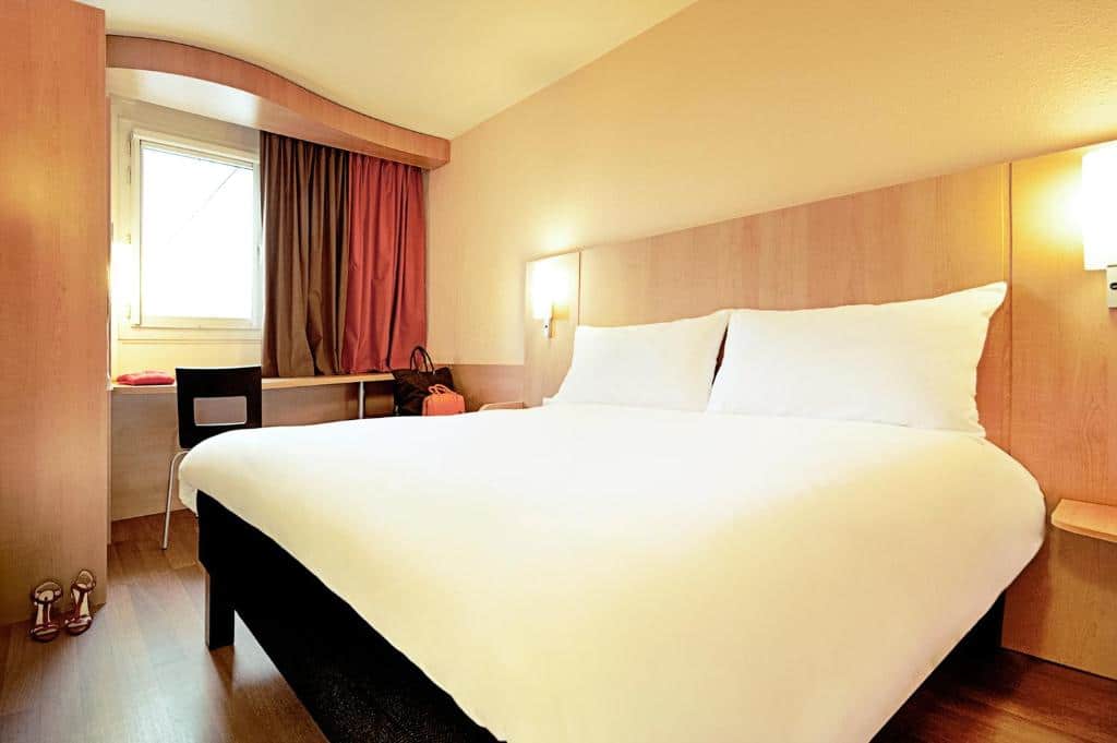 Quarto do ibis Santiago Providencia com cama de casal do lado direito e do lado esquerdo mesa de trabalho, para representar hotéis Mercure em Santiago.