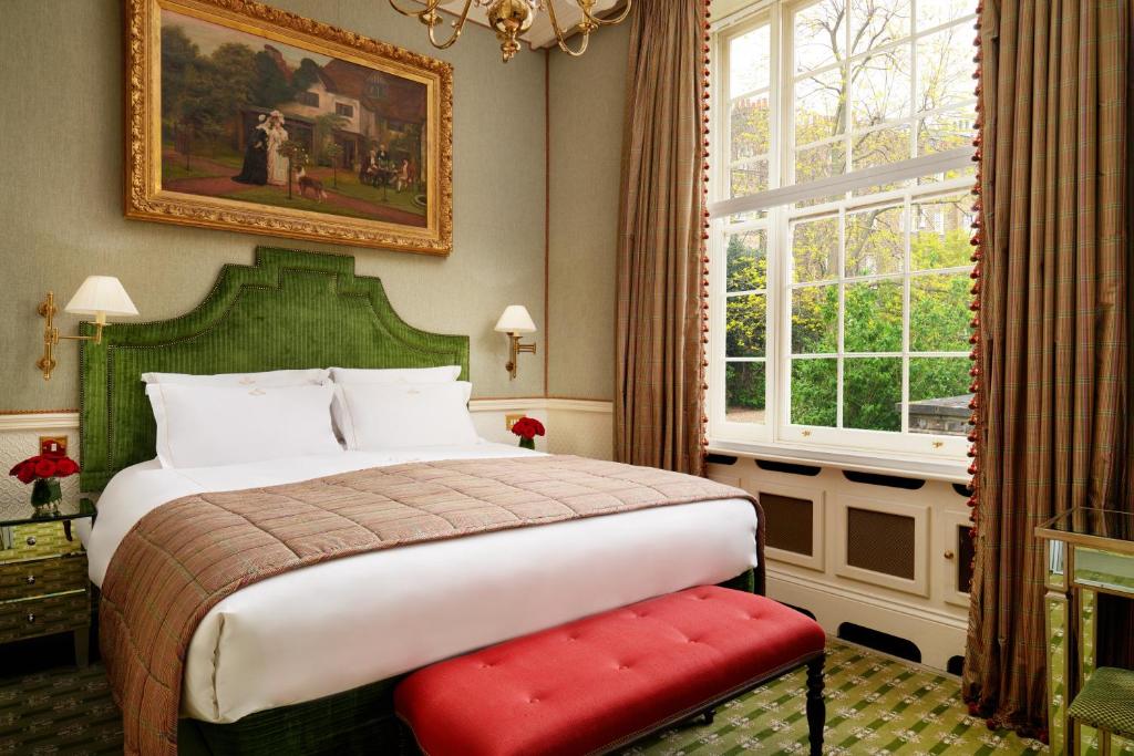 Quarto do The Montague On The Gardens com uma janela ampla com cortinas com vista para um jardim, uma cama de casal, um quadro e um lustre, além de um carpete verde no chão
