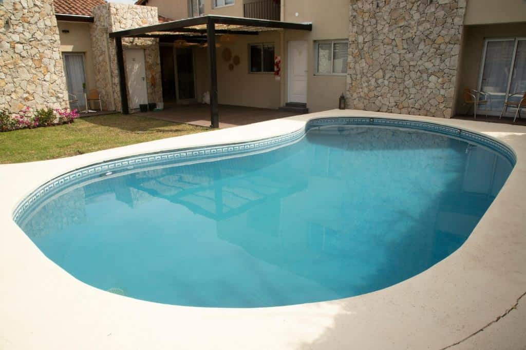 piscina com bordas arredondas em uma varandinha com grama no Rozas Apart, um dos hotéis perto do aeroporto de Buenos Aires