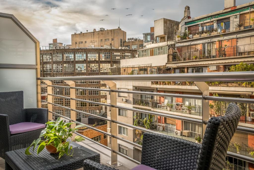 vista da varanda do quarto no Up Recoleta Hotel, um dos hotéis perto do aeroporto de Buenos Aires, com poltronas e mesinha de centro cinzas e com plantinha em cima