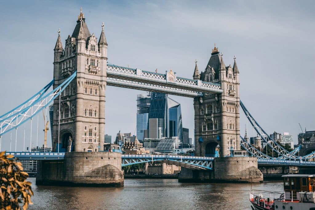 Uma ponte com duas torres altas que marcam a entrada e a saída da ponte, há detalhes em azul e as torres são antigas