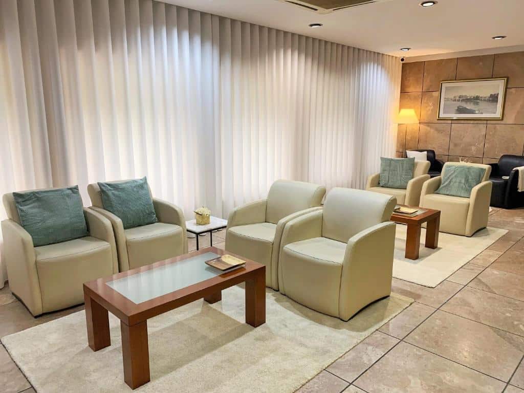 Sala de estar do Hotel Puma com várias poltronas e mesas no ambiente.