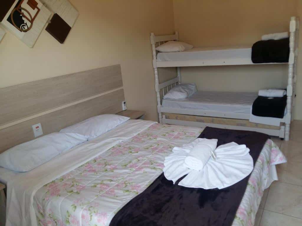 Quarto com uma cama de casal e uma beliche no Hotel Rochamar, um dos hotéis perto do Beto Carrero World