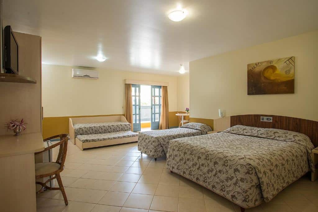 Quarto amplo do Vila Olaria Hotel, um dos hotéis perto do Beto Carrero World, com uma cama de casal ampla, uma cama de solteiro e uma bicama
