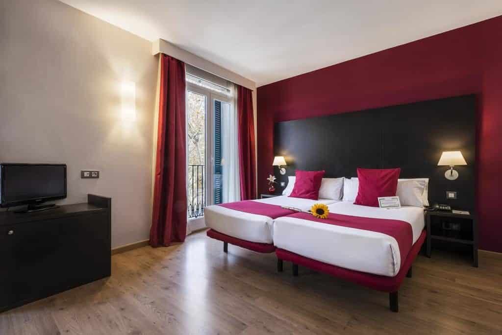 Foto de quarto colorido com girassol na cama para os hóspedes, no Hotel Oriente em Barcelona