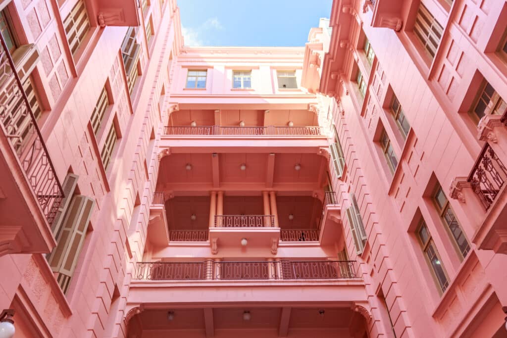 Parte interna rosa da Casa de Cultura Mario Quintana, com varandas e janelas. Imagem para ilustrar post sobre o que fazer em Porto Alegre.