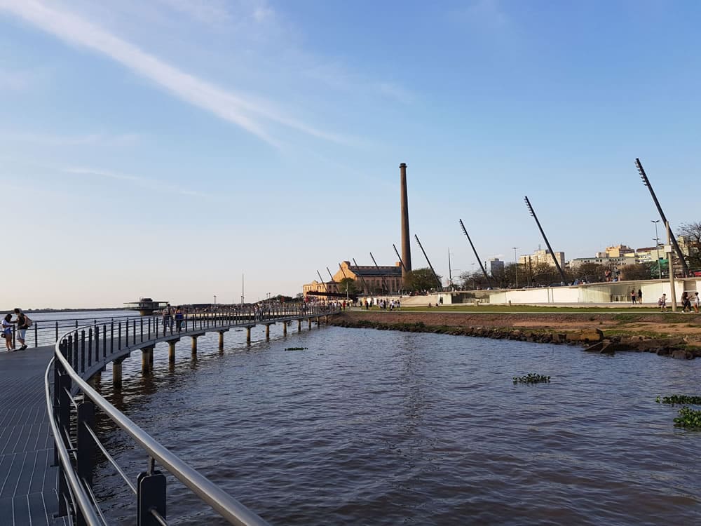 Orla Guaíba, com uma ponte em cima do lago e no canto direito uma passarela. Imagem para ilustrar post sobre o que fazer em Porto Alegre.