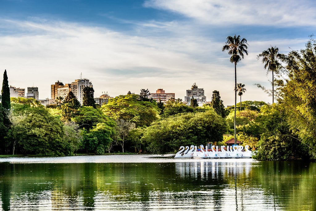Lago do Parque Farroupilha (Redenção), com pedalinhos no lago e ao redor árvores. Imagem para ilustrar post sobre o que fazer em Porto Alegre.