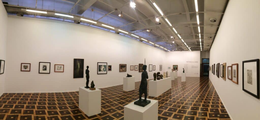 Interior do Museu de Artes do Rio Grande do Sul, com esculturas no meio e quadros nas paredes.