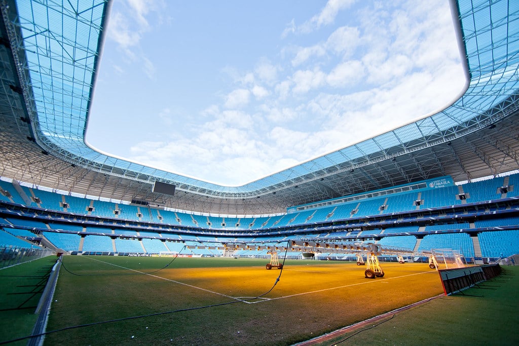Estádio vazio da Arena do Grêmio, com alguns equipamentos no gramado para manutenção. Imagem para ilustrar post sobre o que fazer em Porto Alegre.
