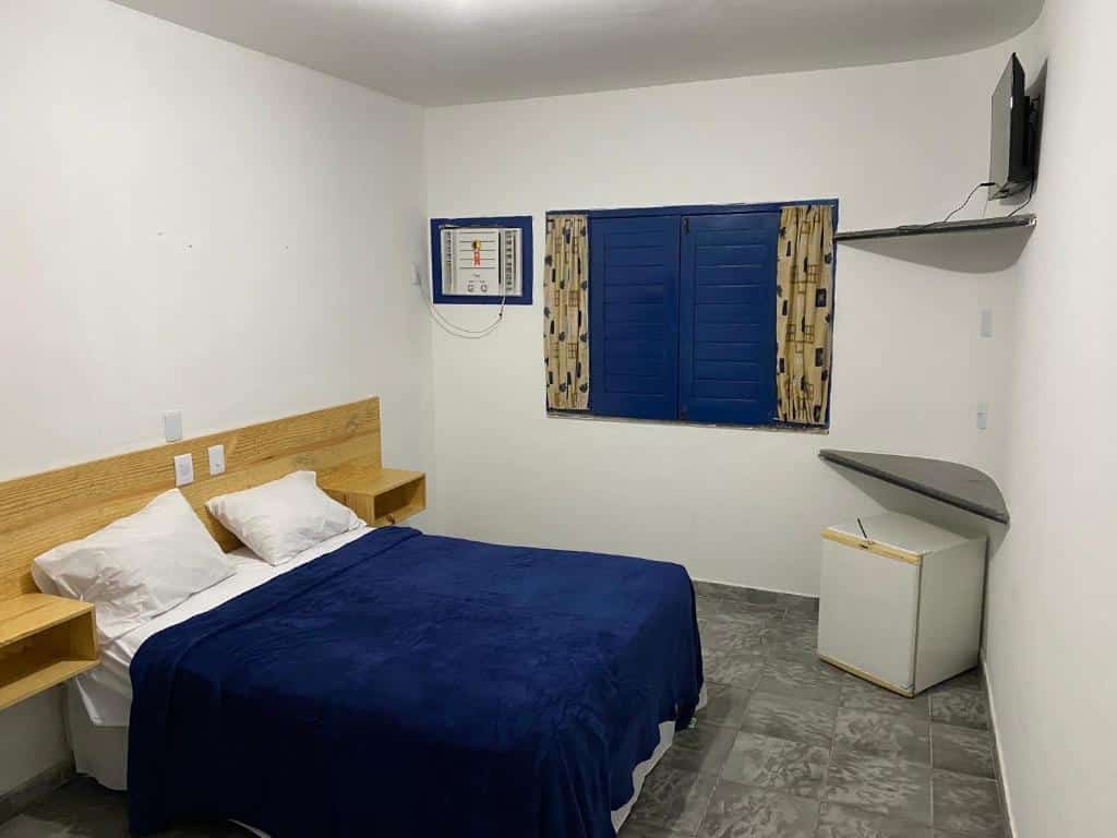 Quarto da Villa Grécia com frigobar, cama de casal, ar-condicionado e TV